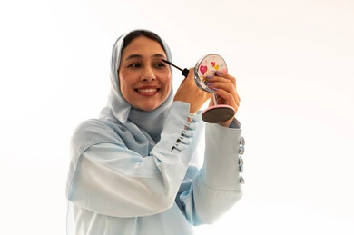 Saudi Woman Applying Mascara with Mirror in Studio
