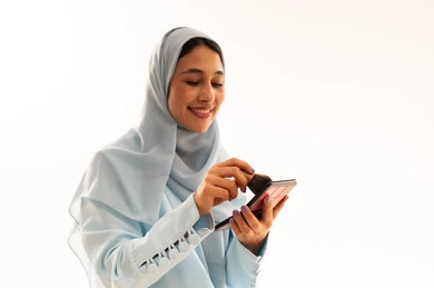 Saudi Woman in Hijab Applying Makeup on White Background