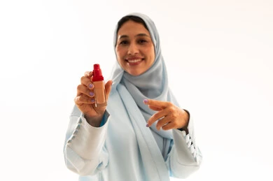 Arab Woman Holding Cosmetic Foundation Bottle in Studio