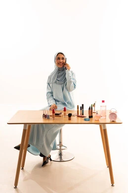 امرأة إماراتية تتحدث بالهاتف على طاولة المكياج
