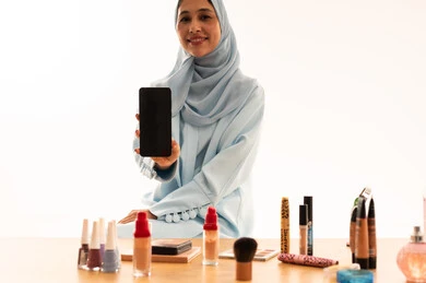 Arab Woman in Hijab Holding Smartphone with Makeup Display