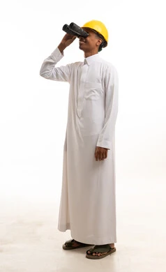 مهندس سعودي بالثوب والخوذة ينظر عبر المنظار