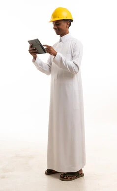 مهندس سعودي بالثوب والخوذة يستخدم جهاز لوحي