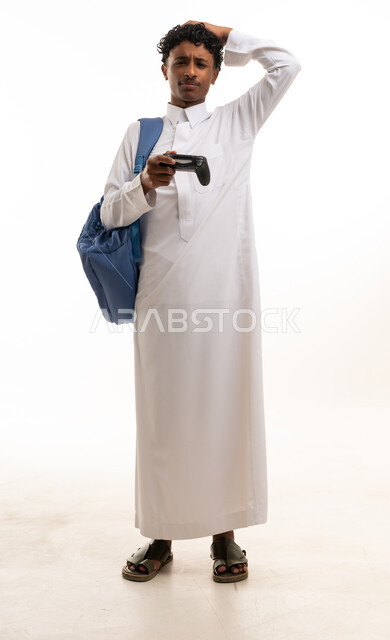 شاب سعودي بالثوب يحمل جهاز تحكم بالألعاب