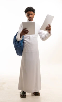 Saudi Male Student in White Thobe Reading Documents