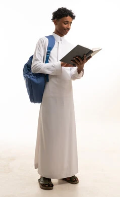 طالب سعودي بالثوب التقليدي يقرأ كتاباً