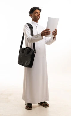 Saudi Man in Traditional White Thobe Reading Document