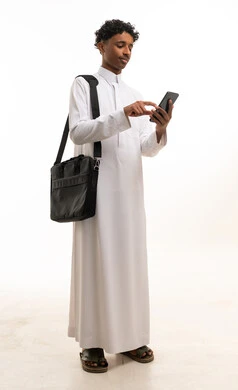 Saudi Man in Traditional Thobe Using Smartphone Studio