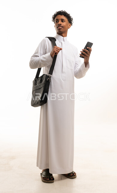شاب سعودي بالثوب الأبيض يحمل هاتف ذكي خلفية بيضاء