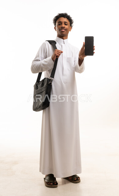 شاب سعودي بالثوب التقليدي يحمل هاتف ذكي