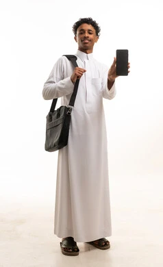 شاب سعودي بالثوب التقليدي يحمل هاتف ذكي