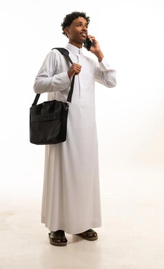 Saudi Man in Traditional Thobe Using Smartphone