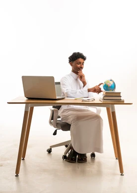 Saudi Student with Globe and Laptop on White Background