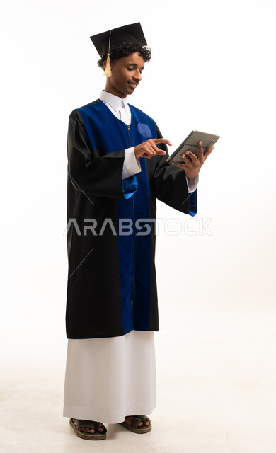 خريج سعودي بلباس التخرج يستخدم جهاز لوحي