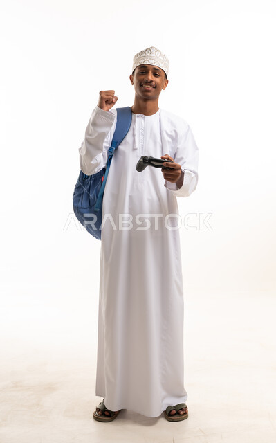 رجل عماني يمسك جهاز تحكم ألعاب على خلفية بيضاء