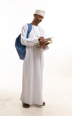 Omani Student in Traditional Dress Writing with Books