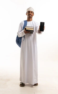 طالب عُماني يحمل كتباً ويعرض هاتفاً ذكياً بخلفية بيضاء