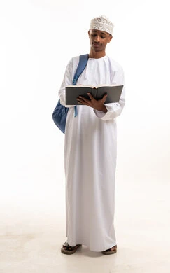 Young Omani Student in Traditional Dress Reading a Book