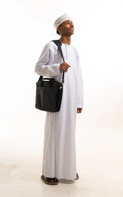 Omani Man in Traditional Dishdasha Carrying Laptop Bag