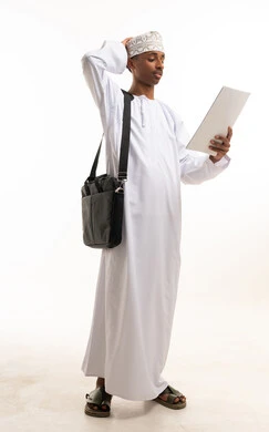 Omani Man in Traditional Dress Reviewing Paper Document