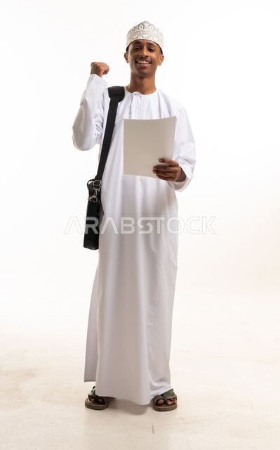 رجل عماني يحتفل بالنجاح مع وثيقة في الاستوديو