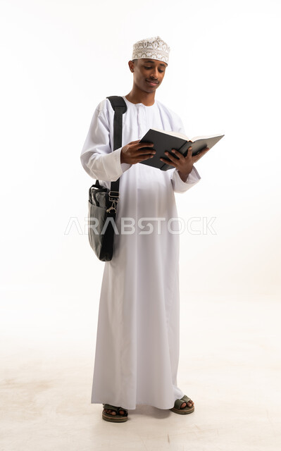 Omani Man in Traditional Dress Reading Book in Studio