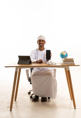 Omani Man at Desk Holding Smartphone on White Background