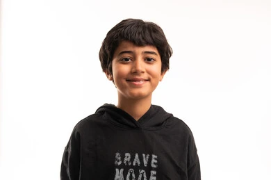 Smiling Arab Boy in Black Hoodie on White Background