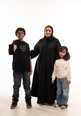 Saudi Mother and Children Holding Smartphone in Studio