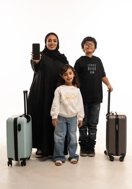 Saudi Family with Suitcases Holding Smartphone