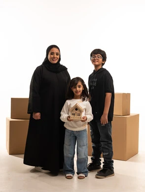 Saudi Family with House Model and Moving Boxes Saudi Family with House Model and Moving Boxes