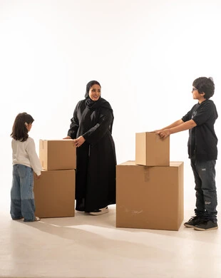 عائلة عربية مع صناديق كرتونية لنقل المنزل في استوديو