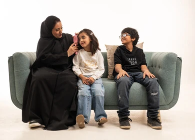 Saudi Mother Brushing Daughter Hair on Sofa