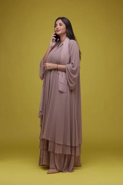 Saudi Woman Talking on Smartphone with Yellow Background
