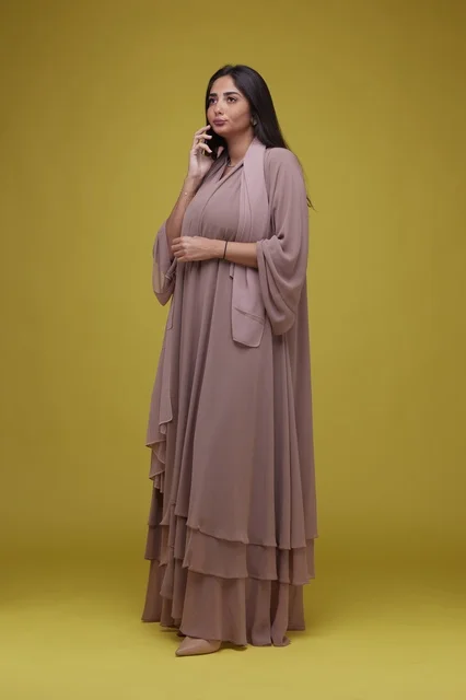 Saudi Woman using Smartphone against Yellow Background