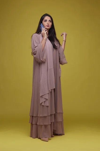 Young Saudi Woman Talking on Smartphone in Elegant Beige Abaya