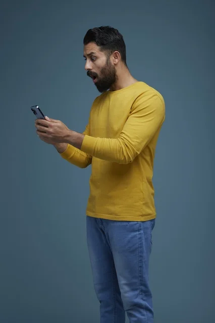 Shocked Saudi Man Using Smartphone in Casual Wear