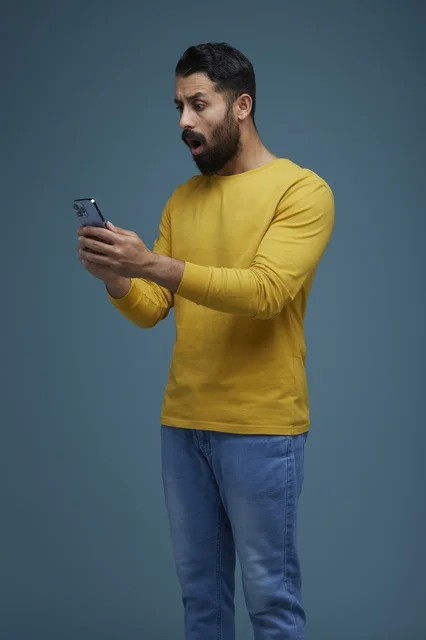 Shocked Saudi Man Using Smartphone in Casual Wear