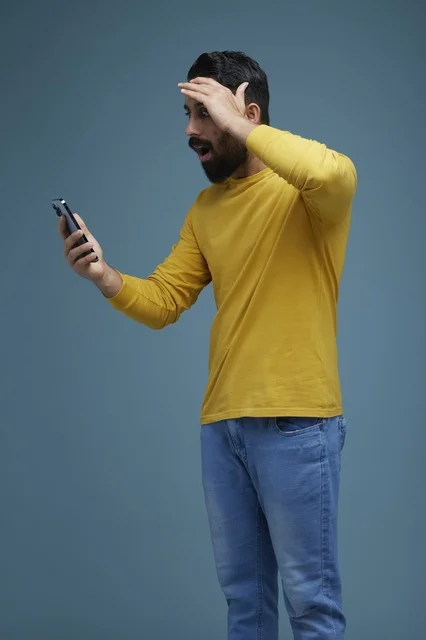 Shocked Saudi Man Using Smartphone in Casual Clothes
