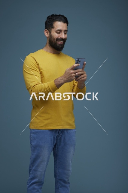 Saudi Man Using Smartphone in Casual Yellow Shirt