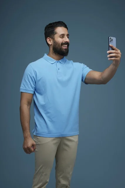Saudi Man Taking Selfie with Smartphone in Blue Polo
