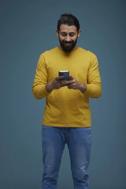 Saudi Man Using Smartphone in Casual Yellow Shirt