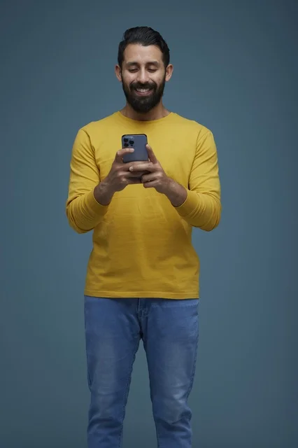 Saudi Man Using Smartphone in Yellow Casual Shirt