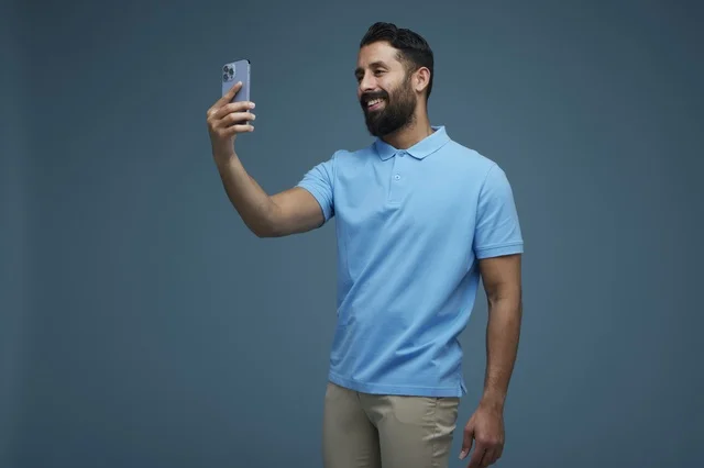 Saudi Man Taking Selfie with Smartphone in Blue Polo