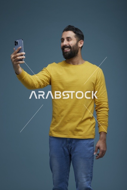 شاب سعودي يلتقط سيلفي بالهاتف الذكي بملابس كاجوال