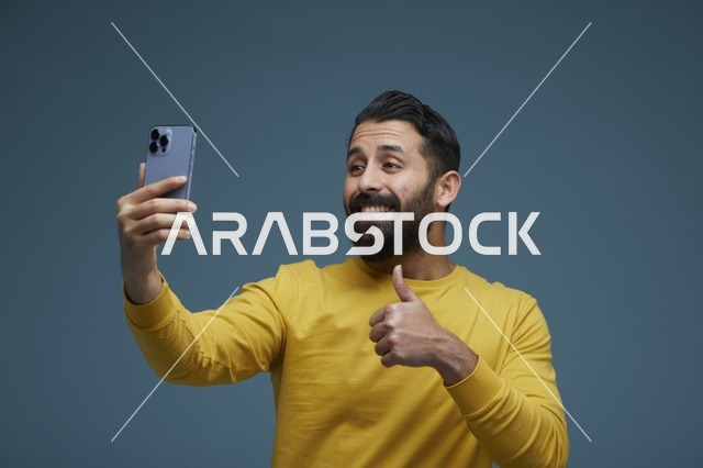 شاب سعودي يلتقط سيلفي بالهاتف الذكي مع علامة الإعجاب