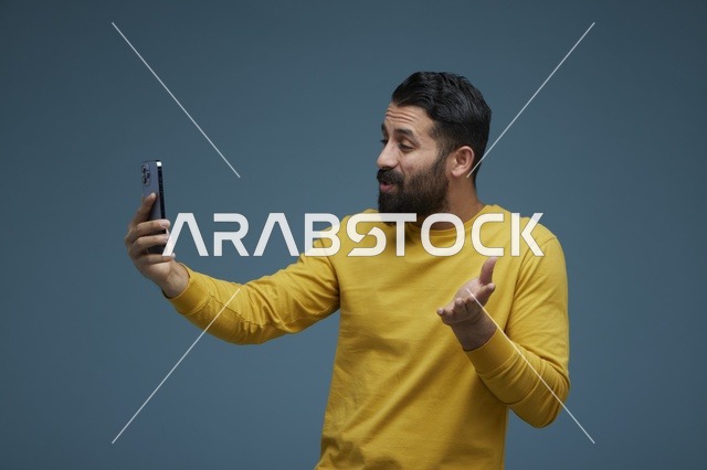 شاب سعودي يلتقط سيلفي بالهاتف الذكي في الاستوديو