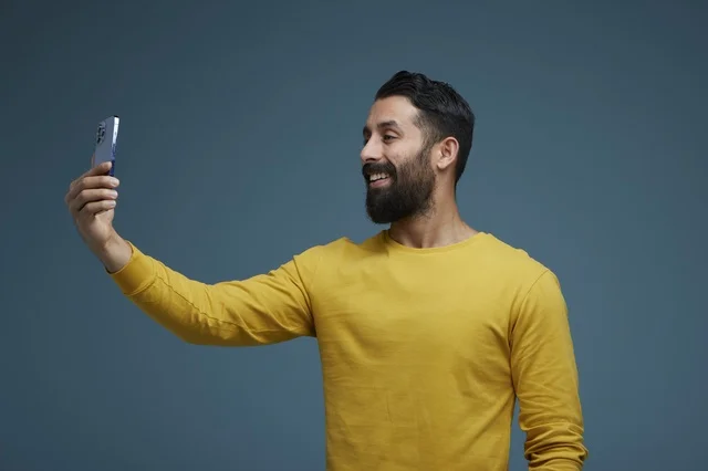 Saudi Man Taking Smartphone Selfie in Casual Yellow Shirt