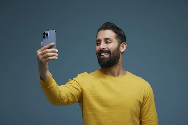 Saudi Man Taking Selfie with Smartphone in Studio Background