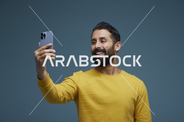 شاب سعودي يلتقط سيلفي بالهاتف الذكي بملابس كاجوال